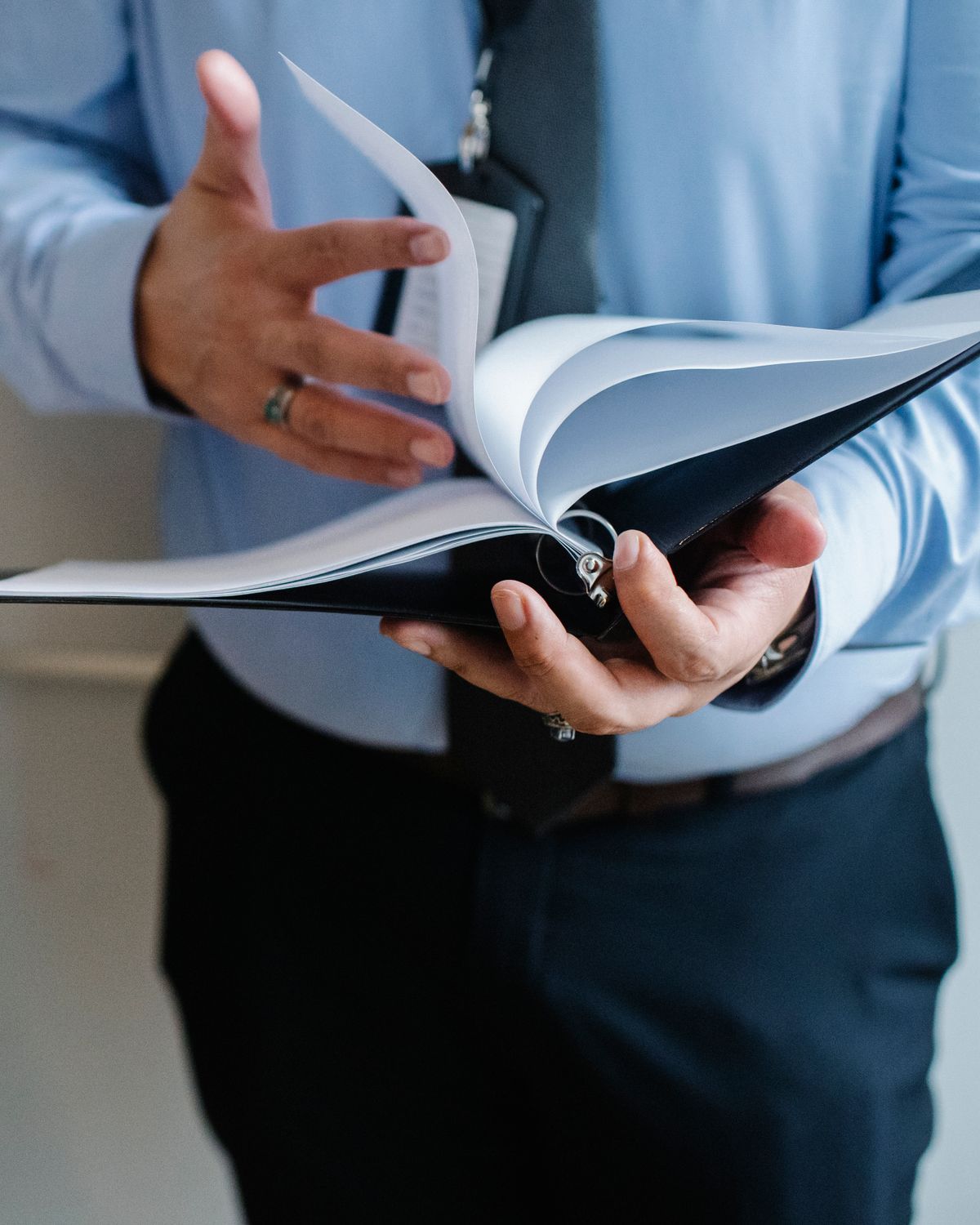 Professional leafing through a bound corporate dossier